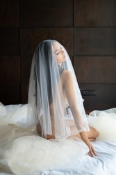 Asian woman wrapped in white fabric, beautiful slim.Naked woman art in white light transparent dress posing on a bed.
