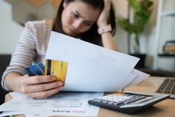 stressed woman trying money to pay credit card debt and many expenses bills such as electricity bill,water bill,internet bill,phone bill during covid-19 or coronavirus outbreak at home
