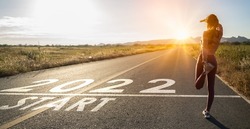 New year 2022 or straight forward concept.Word 2022 written on the road in the middle of asphalt road at sunset.Concept of planning and challenge,hope,new life change,business strategy,opportunity 