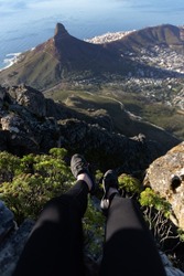 Woman on Table Mountain watching Cape Town. Tourist on the top of a high rock. Concept sport and active life.