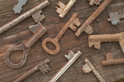 Antique steel keys on old wooden background