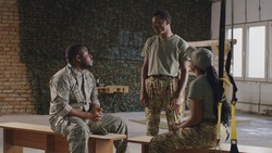 Black soldier talking with squadmates in gym