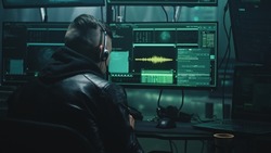 Young man with headset stealing private data from victim by making call from high tech base with computers