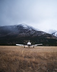 An aircraft landed on a field by mountains