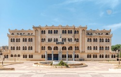 School building facade with Algerian flag and an arabic signboard says