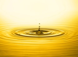 Golden water drop and splash close up