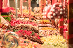Candies, mainly gummy sweets and lollilpops, diversified, display in loose in a candy shop during a carnival or a fair, typical from the holidays and christmas period.

