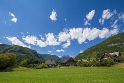 Residential house, slovenian chalet, in a grass field in front of Triglav, Mali Draski, Tosc and Skrlatica mounts in the Julian Alps, in Slovenia. Triglav vrh is highest peak and mountain of Slovenia