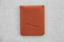 Handmade tanned leather minimalist wallet close-up. (Red, brown and light brown.) Women's and men's leather accessories.