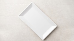 Rectangular white plate on a light stone background, the concept of food, restaurant