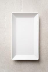 Rectangular white plate on a light stone background, the concept of food, restaurant