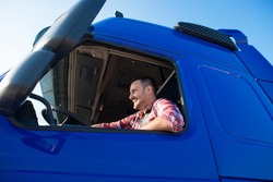 Truck driver sitting in his cabin driving his truck. Logistics and fast transportation services.