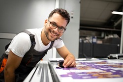 Portrait of an experienced print worker controlling print quality in modern printing house.