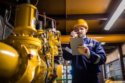 Refinery worker supervisor checking natural gas consumption and pipeline installations in petrochemical industry.