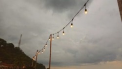 Blur image of hanging lamp with a view of mountains and sky