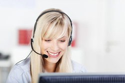Female call center operator with headphone browsing on her computer