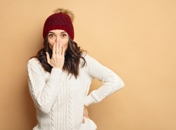Happy Young Beautiful Woman in winter clothes Surprised on soft background with copy space. Sales and discount concept