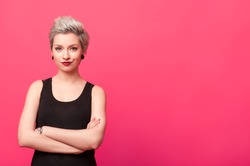 confident woman standing with arms crossed isolated over pink background