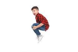 Side view of excited young boy jumping isolated on white. 