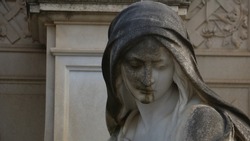 somber stone carved lady at cemetary