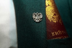 Badge with a Russian double-headed eagle on the lapel of the jacket, Russian symbols, Russian passport