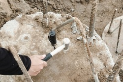Seismic test on concrete pile. Engineer using the PIT Hand-Held Hammer, the PIT Accelerometer and the Pile Integrity Tester to detect Neck Bulge and Void in the piles