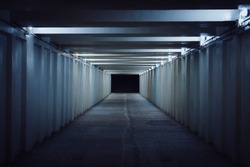 Underground pedestrian crossing. A long concrete tunnel with lanterns in the city underground. Underpass. underground passage