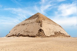 View of Pyramid of Snefru, Bent Pyramid on a blue sky background, at Dahshur, Egypt. The southern pyramid in Dahshur is called cut or diamond-shaped because of its irregular shape.