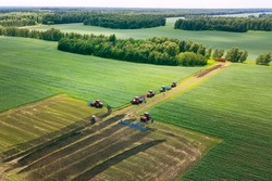 Tractor with plow on soil cultivating. tractor bowling field, drone view. Cultivated plant and soil tillage. Agricultural tractors on field cultivation. Tractor disk harrow on plowing farm field.