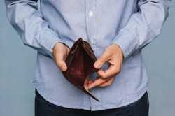 Bankruptcy - Business Person holding an empty wallet. Man showing empty wallet by showing the inconsistency and lack of money and not able to pay the loan and the mortgage.