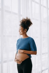 pregnant african american woman at home window white background space