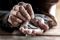 Hand the old man and pile coin for saving. money saving concept.