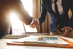 Two confident business man shaking hands during a meeting in the office, success, dealing, greeting and partner in sun light
