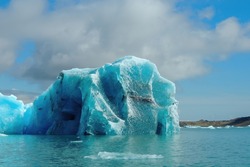 Bright clear blue turquoise iceberg floating in the Jokulsarlon lake blue cold water in Iceland