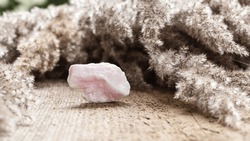 Raw Uncut Pink Manganocalcite or Manganoan Calcite Stone Specimen on Wooden Background. Natural Minerals and Healing Stones Collection
