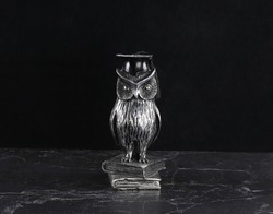 owl figurine, a symbol of wisdom on a black background