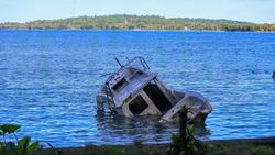 An old and damaged boat is on the coast in Manokwari, West Papua