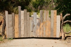 Old rustic wooden fence with lock blocking country lane 