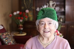 Cute granny wearing green shiny turban and pearls necklace