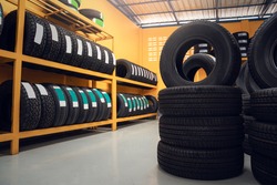 Large warehouse of car tires, rack with customer car tires in warehouse of a tire dealer