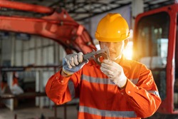 A technician mechanic man use vernier caliper and holding bulldozer sprocket to inspection and repair maintenance heavy machinery, Industrial Theme.