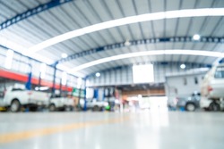 Blurred of Automotive industry, Car repair service center the epoxy floor in car factory service , The interior of a big industrial building or factory with steel constructions. Steel roof frame.