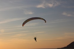 Paragliding with sunset reverse light, parachute with amazing sky