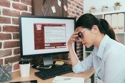 sadness company agent woman finding working computer getting blackmail virus attack thinking solution at office desk and feeling depression.