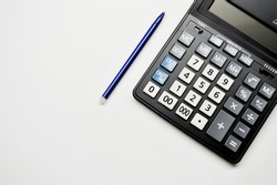 Accountant's Day. Calculator and pen on white background with copy space.