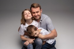 portrait of happy father and cheerful son, cute boy playing with dad in the house, child hugging father, dad playing with children, dad hugs daughter