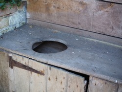 Ancient wooden toilet cabinet in brick outhouse. 