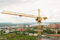 tower crane top view. building background river, sunset, mountains. concept construction, new buildings, architecture and industry. construction big city against backdrop city mountains