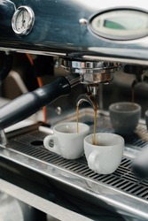 Making coffee espresso or ristretto in coffee machine. Home making hot Espresso. Coffee with froth. Espresso in a white cup. Tasty coffee. Caffeine.