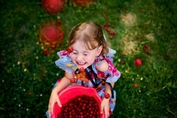 Beautiful girl in the garden. Happy girl with cherries. Girl in the cherry orchard. Cherries. The Cherry Orchard. Beautiful girl tosses berries. Berries. Childhood. Delicious cherries. 